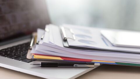 Unterlagen, die auf einem Laptop liegen. Unterlagen, die auf einem Laptop liegen.