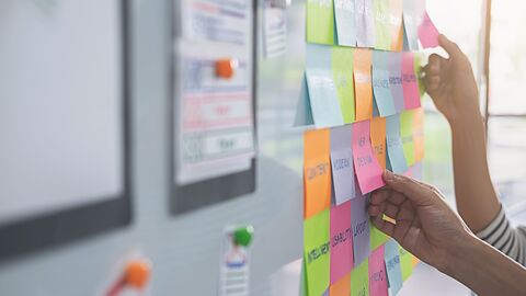 Farbige Klebezettel kleben an einem Smartboard Farbige Klebezettel kleben an einem Smartboard