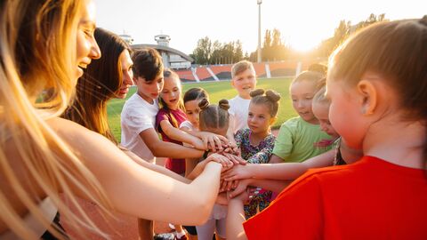 Jugendliche stehen in einem Kreis und halten ihre Hände als Form des Zusammenhalts zusammen. Jugendliche stehen in einem Kreis und halten ihre Hände als Form des Zusammenhalts zusammen.